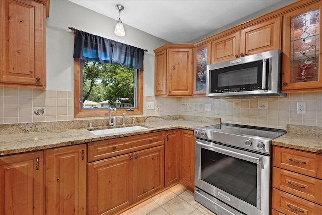 6196 N River Trail Dr, Milwaukee, WI 53225 - kitchen with appliances with stainless steel finishes, glass insert cabinets, light stone counters, and brown cabinetry