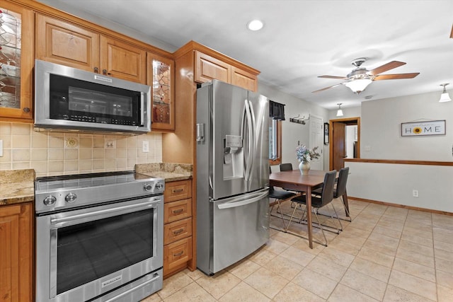 6196 N River Trail Dr, Milwaukee, WI 53225 - kitchen featuring stainless steel appliances, decorative backsplash, a ceiling fan, glass insert cabinets, and brown cabinetry