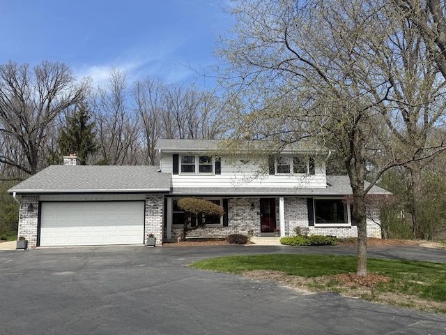 10500 W Good Hope Rd, Milwaukee, WI 53224 - traditional-style home featuring driveway, an attached garage, brick siding, a chimney, and roof with shingles
