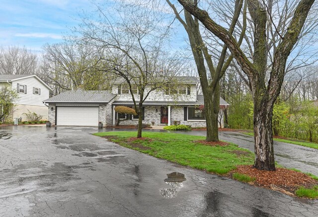 10500 W Good Hope Rd, Milwaukee, WI 53224 - traditional-style home featuring an attached garage, asphalt driveway, brick siding, and a front lawn