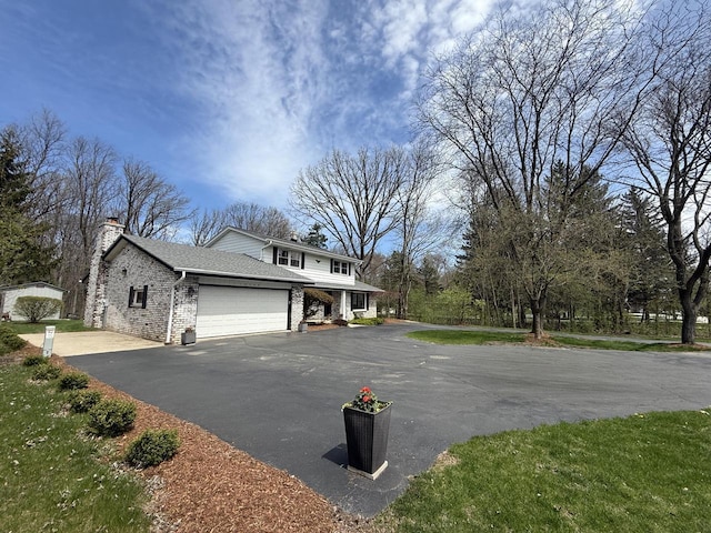10500 W Good Hope Rd, Milwaukee, WI 53224 - view of front of property with an attached garage, asphalt driveway, a chimney, and brick siding