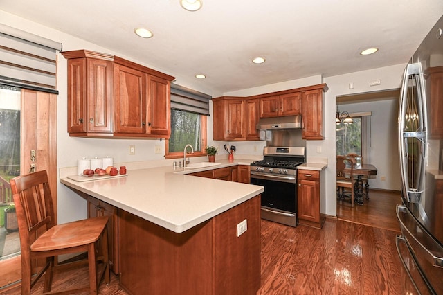 10500 W Good Hope Rd, Milwaukee, WI 53224 - kitchen with appliances with stainless steel finishes, under cabinet range hood, a peninsula, light countertops, and dark wood-style floors