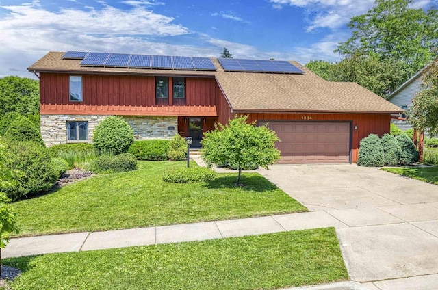 1334 W Cloverdale Dr, Appleton, WI 54914 - view of front facade featuring an attached garage, a front yard, solar panels, and stone siding