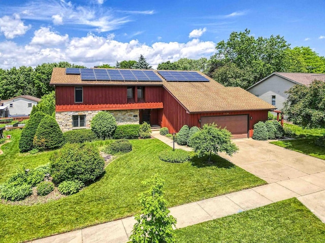 1334 W Cloverdale Dr, Appleton, WI 54914 - view of front of property with stone siding, an attached garage, a front lawn, and roof mounted solar panels