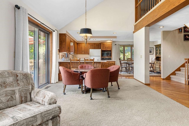 1334 W Cloverdale Dr, Appleton, WI 54914 - dining room featuring high vaulted ceiling, light wood finished floors, light carpet, and stairway