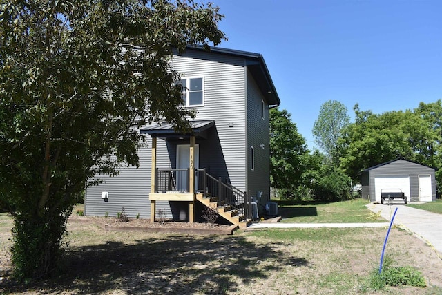 120 Eleonor St, Two Rivers, WI 54241 - view of home's exterior with a detached garage, an outbuilding, a lawn, and driveway