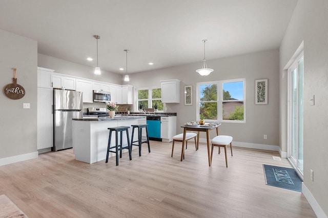 120 Eleonor St, Two Rivers, WI 54241 - kitchen featuring stainless steel appliances, a center island, a kitchen bar, light wood-type flooring, and recessed lighting