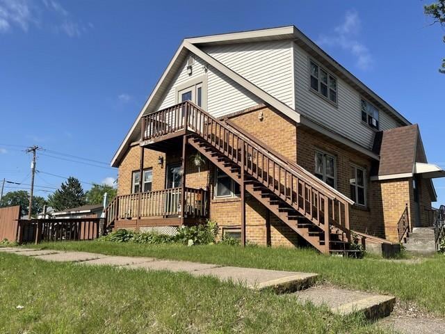 427 N 5th St, Tomahawk, WI 54487 - rear view of property featuring brick siding, stairs, and a deck