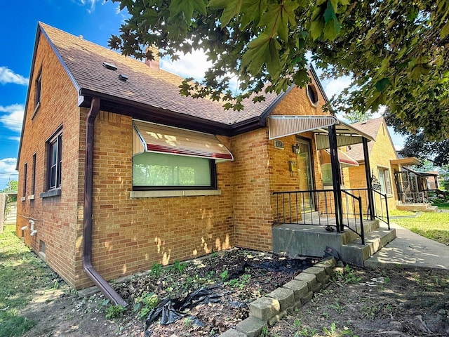 6352 W Medford Ave, Milwaukee, WI 53218 - view of side of property featuring brick siding, roof with shingles, and a chimney