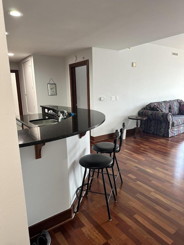 333 W Mifflin St Unit 1156, Madison, WI 53703 - kitchen featuring a kitchen breakfast bar, dark wood-type flooring, dark countertops, recessed lighting, and open floor plan
