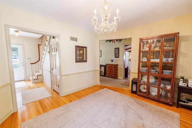 2278 S Riverside Dr, Beloit, WI 53511 - hall with stairs, light wood finished floors, and a chandelier