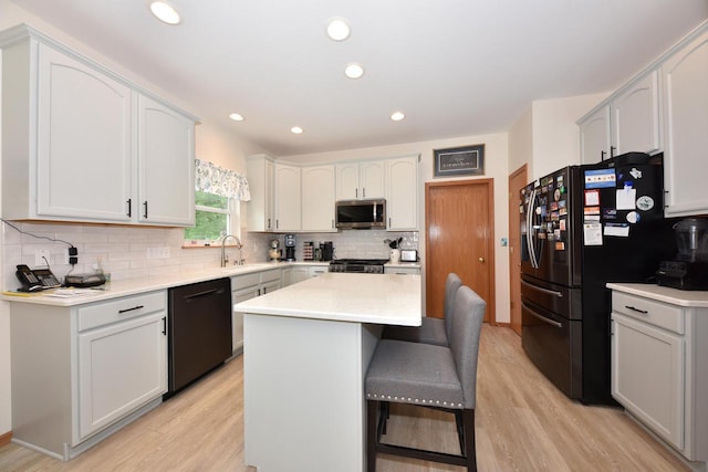 847 Chisholm Ln, Port Washington, WI 53074 - kitchen with dishwasher, stainless steel microwave, light wood-style flooring, freestanding refrigerator, and decorative backsplash