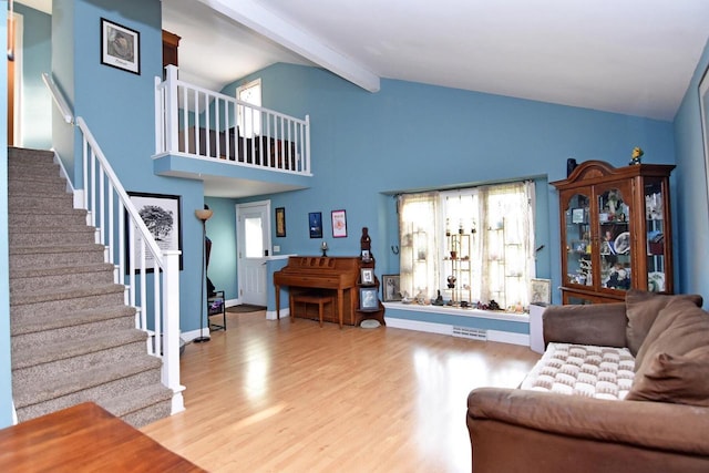 6401 237th Ave, Salem, WI 53168 - living room featuring wood finished floors, beam ceiling, stairway, and high vaulted ceiling