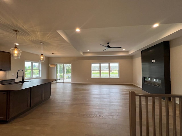1310 Spahn Dr, Waunakee, WI 53597 - kitchen featuring a ceiling fan, light wood finished floors, recessed lighting, dark brown cabinets, and open floor plan