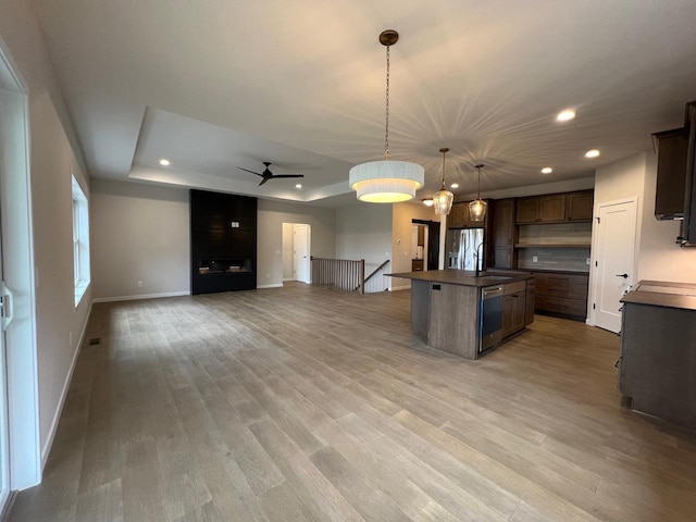 1310 Spahn Dr, Waunakee, WI 53597 - kitchen with dark countertops, recessed lighting, a raised ceiling, stainless steel appliances, and open floor plan