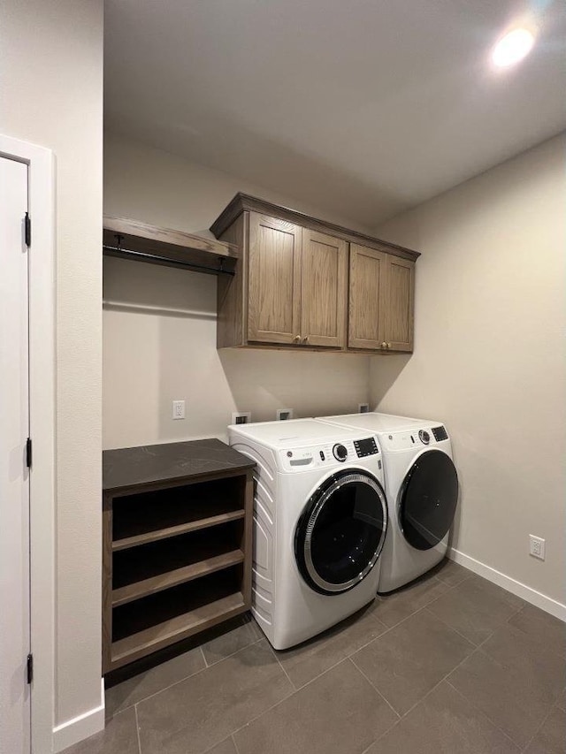 1310 Spahn Dr, Waunakee, WI 53597 - laundry area featuring cabinet space, washing machine and clothes dryer, and dark tile patterned flooring
