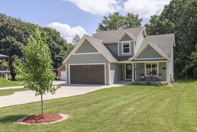2335 Macarthur Rd, Waukesha, WI 53188 - view of front of property with driveway, a porch, an attached garage, a front lawn, and a shingled roof