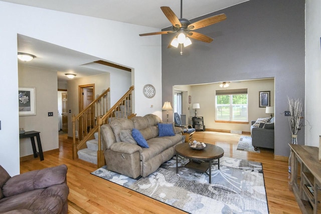 2335 Macarthur Rd, Waukesha, WI 53188 - living room featuring stairway, light wood-style flooring, ceiling fan, and a high ceiling