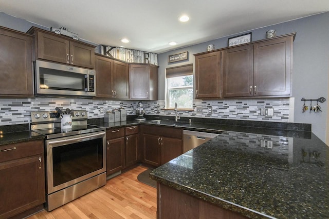 2335 Macarthur Rd, Waukesha, WI 53188 - kitchen with stainless steel appliances, light wood-style floors, dark brown cabinetry, decorative backsplash, and recessed lighting