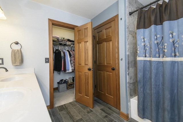 2335 Macarthur Rd, Waukesha, WI 53188 - bathroom featuring wood finish floors, shower / bath combination with curtain, a spacious closet, and double vanity