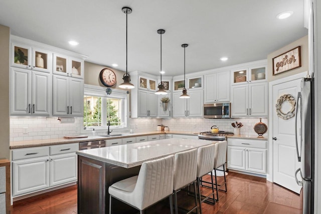 1007 Waterford Ln, Waunakee, WI 53597 - kitchen featuring appliances with stainless steel finishes, dark wood-type flooring, white cabinets, decorative light fixtures, and recessed lighting