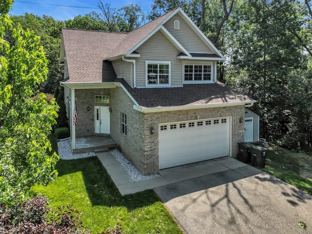N8986 Swift Lake Dr, East Troy, WI 53120 - traditional-style house with roof with shingles, driveway, a garage, and brick siding