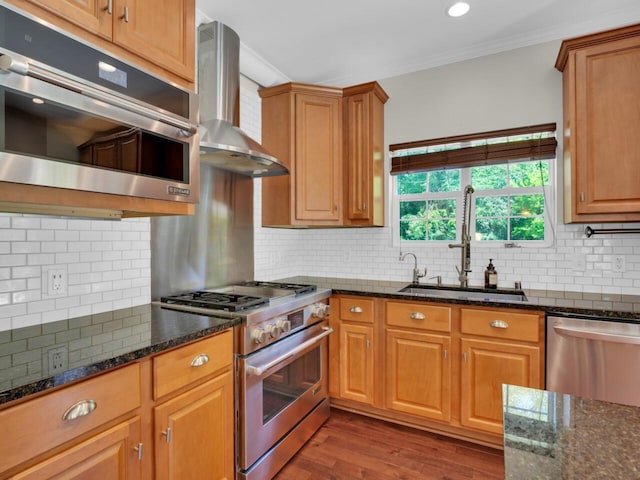 N8986 Swift Lake Dr, East Troy, WI 53120 - kitchen featuring stainless steel appliances, wall chimney exhaust hood, ornamental molding, wood finished floors, and dark stone countertops