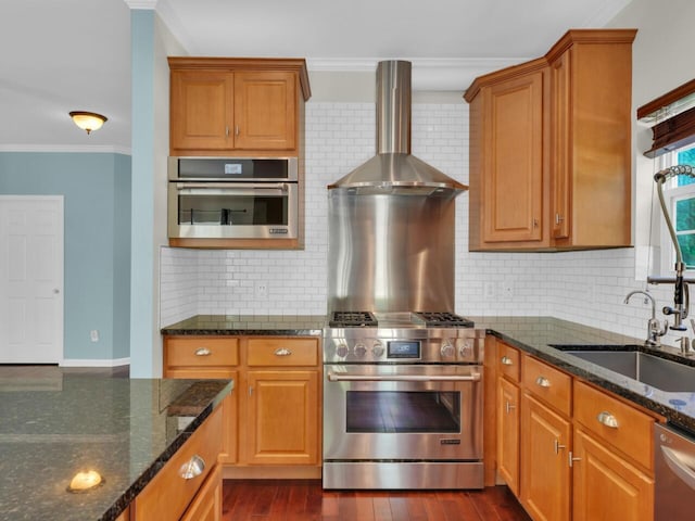 N8986 Swift Lake Dr, East Troy, WI 53120 - kitchen featuring wall chimney exhaust hood, appliances with stainless steel finishes, decorative backsplash, dark stone countertops, and ornamental molding