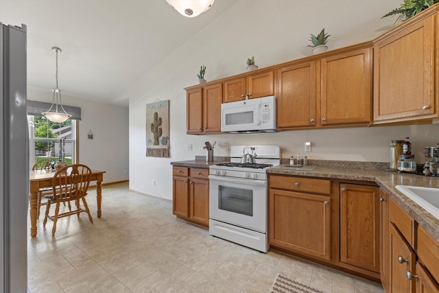 10724 S Christina Ct, Oak Creek, WI 53154 - kitchen featuring white appliances, brown cabinets, pendant lighting, lofted ceiling, and dark countertops