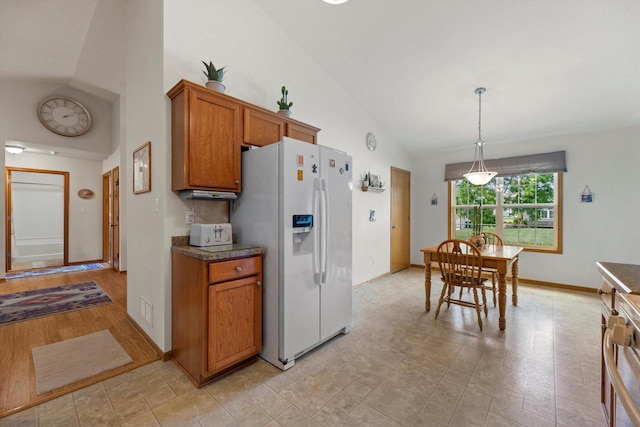 10724 S Christina Ct, Oak Creek, WI 53154 - kitchen with white fridge with ice dispenser, high vaulted ceiling, brown cabinetry, dark countertops, and pendant lighting
