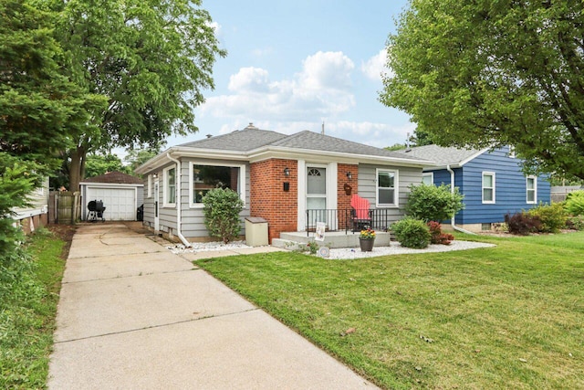 1104 Lathrop Ave, Racine, WI 53405 - view of front facade featuring concrete driveway, a front yard, an outdoor structure, and a detached garage