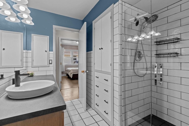 2015 E College Ave, Appleton, WI 54915 - ensuite bathroom featuring vanity, a shower stall, a chandelier, tile patterned floors, and wainscoting