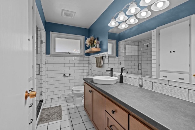 2015 E College Ave, Appleton, WI 54915 - bathroom with vanity, a tile shower, tile patterned flooring, and tile walls