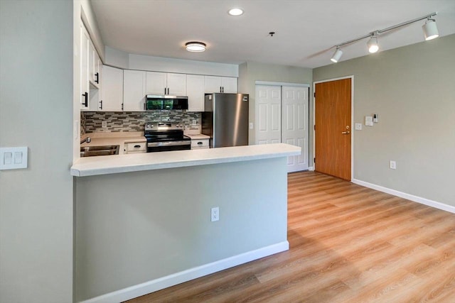 201 Kearney Way Unit 201, Waunakee, WI 53597 - kitchen with appliances with stainless steel finishes, a peninsula, light countertops, backsplash, and white cabinets