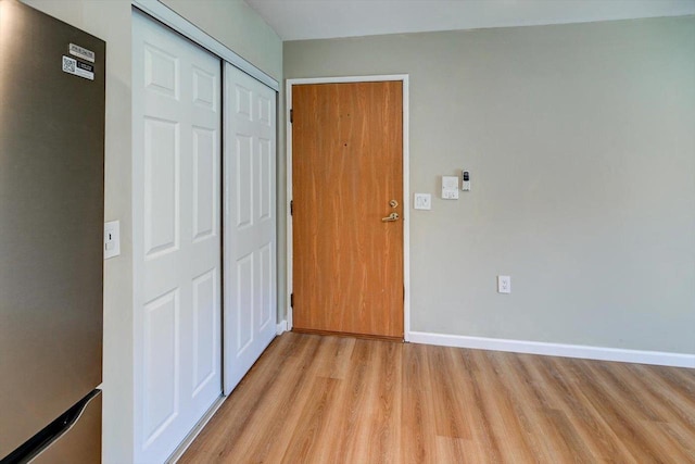 201 Kearney Way Unit 201, Waunakee, WI 53597 - unfurnished bedroom with refrigerator, light wood-style floors, and a closet