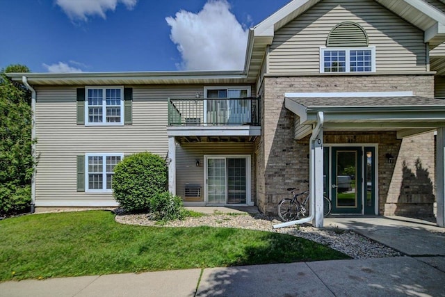 201 Kearney Way Unit 201, Waunakee, WI 53597 - view of front facade with a balcony and a front lawn