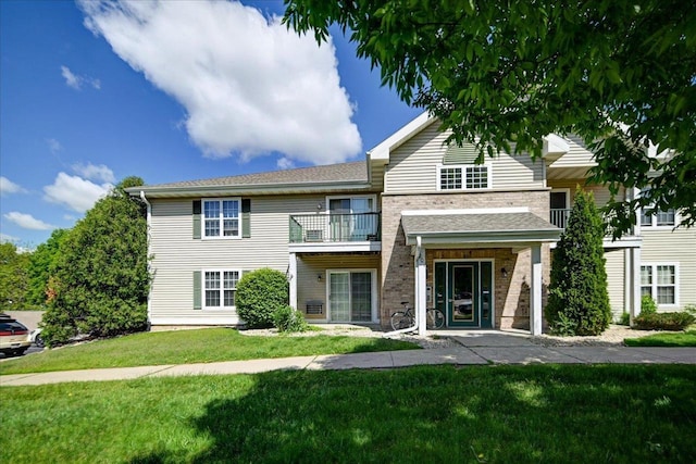 201 Kearney Way Unit 201, Waunakee, WI 53597 - view of front of house with a front lawn, a balcony, and brick siding