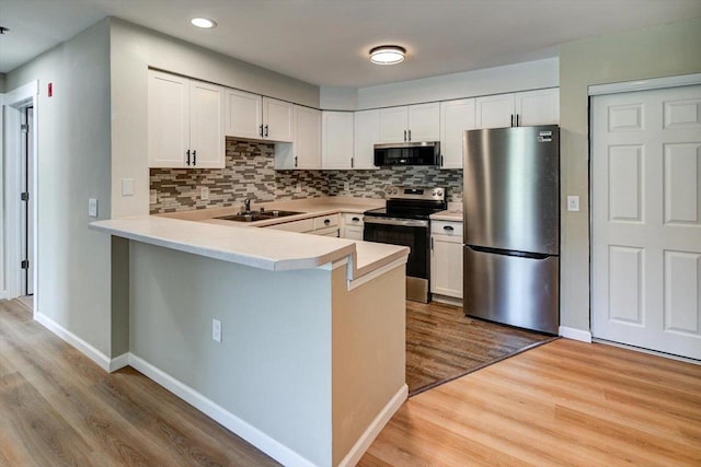 201 Kearney Way Unit 201, Waunakee, WI 53597 - kitchen with appliances with stainless steel finishes, a peninsula, light wood-style flooring, backsplash, and recessed lighting