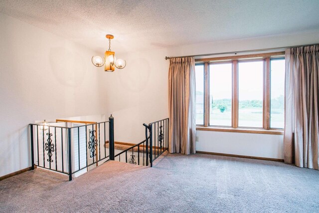 403 Bluebird Ln, Loyal, WI 54446 - empty room featuring carpet, a chandelier, and a textured ceiling
