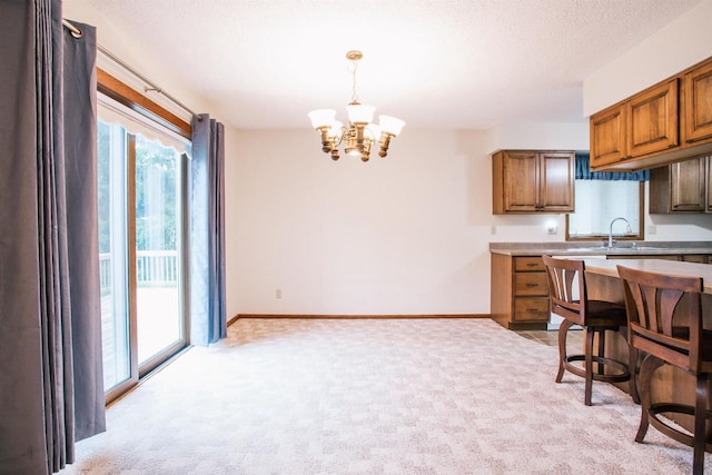 403 Bluebird Ln, Loyal, WI 54446 - kitchen featuring a chandelier, light carpet, light countertops, and hanging light fixtures