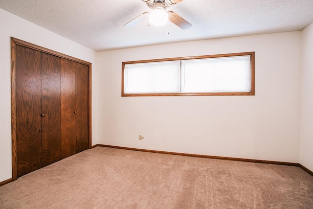 403 Bluebird Ln, Loyal, WI 54446 - unfurnished bedroom featuring multiple windows, carpet flooring, a closet, a textured ceiling, and a ceiling fan