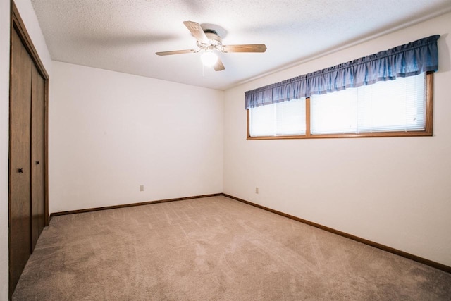 403 Bluebird Ln, Loyal, WI 54446 - unfurnished bedroom with light colored carpet, a closet, a ceiling fan, and a textured ceiling