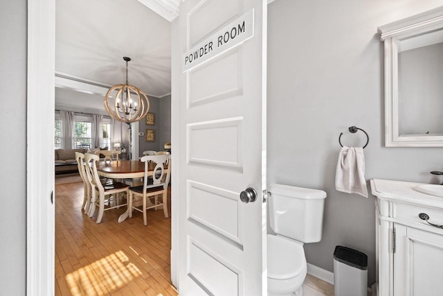 622 Grant St, Fort Atkinson, WI 53538 - half bathroom with a chandelier, vanity, and wood-type flooring