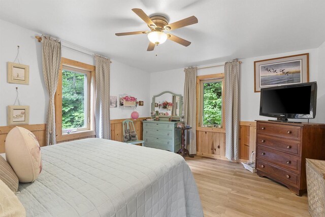 17705 Nicolet Rd, Townsend, WI 54175 - bedroom with multiple windows, wainscoting, light wood-style floors, and ceiling fan