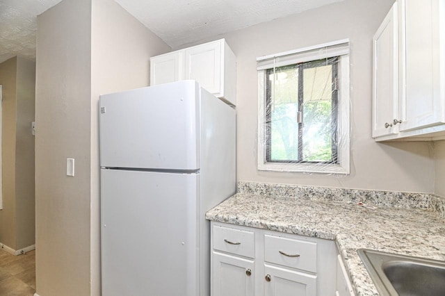 9618 W Bradley Rd, Milwaukee, WI 53224 - kitchen featuring freestanding refrigerator, white cabinetry, and a textured ceiling