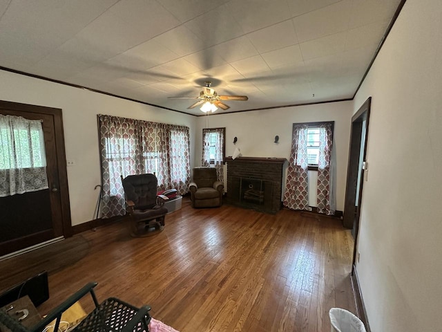211 N Main St, Viola, WI 54664 - living room featuring hardwood / wood-style flooring, crown molding, a ceiling fan, and a fireplace