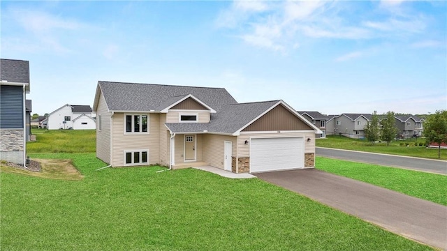 198 Pintail St, Baldwin, WI 54002 - view of front of property with asphalt driveway, a garage, stone siding, a front lawn, and a shingled roof