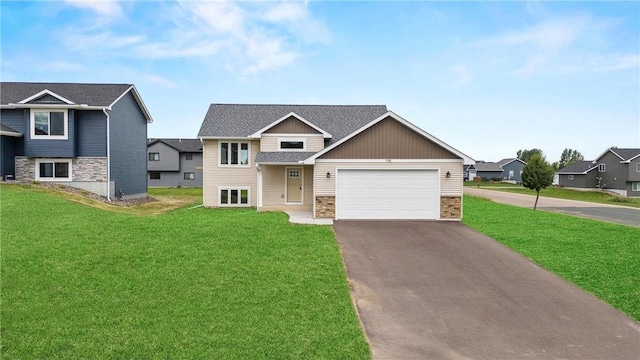 198 Pintail St, Baldwin, WI 54002 - view of front facade featuring stone siding, asphalt driveway, a garage, and a front lawn