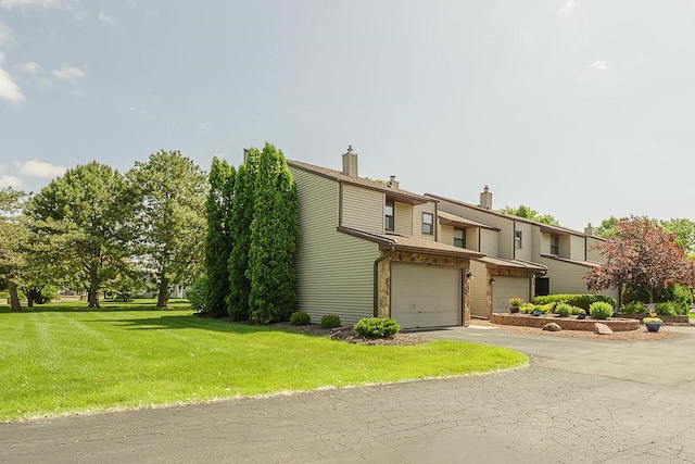630 Brule Rd Unit 11, De Pere, WI 54115 - view of front of home featuring a garage, driveway, a chimney, and a front lawn