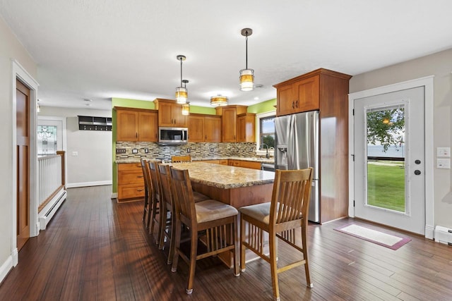 4350 S US Highway 45, Oshkosh, WI 54902 - kitchen with appliances with stainless steel finishes, baseboard heating, tasteful backsplash, dark wood-type flooring, and healthy amount of natural light